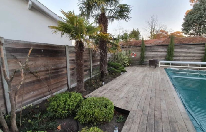 Entretien de jardin avec terrasse bois et aménagement paysager autour d’une piscine par NC Paysages